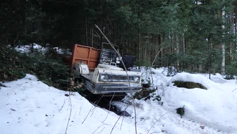 forest machine stuck inside the snow, a young man is walking in the background