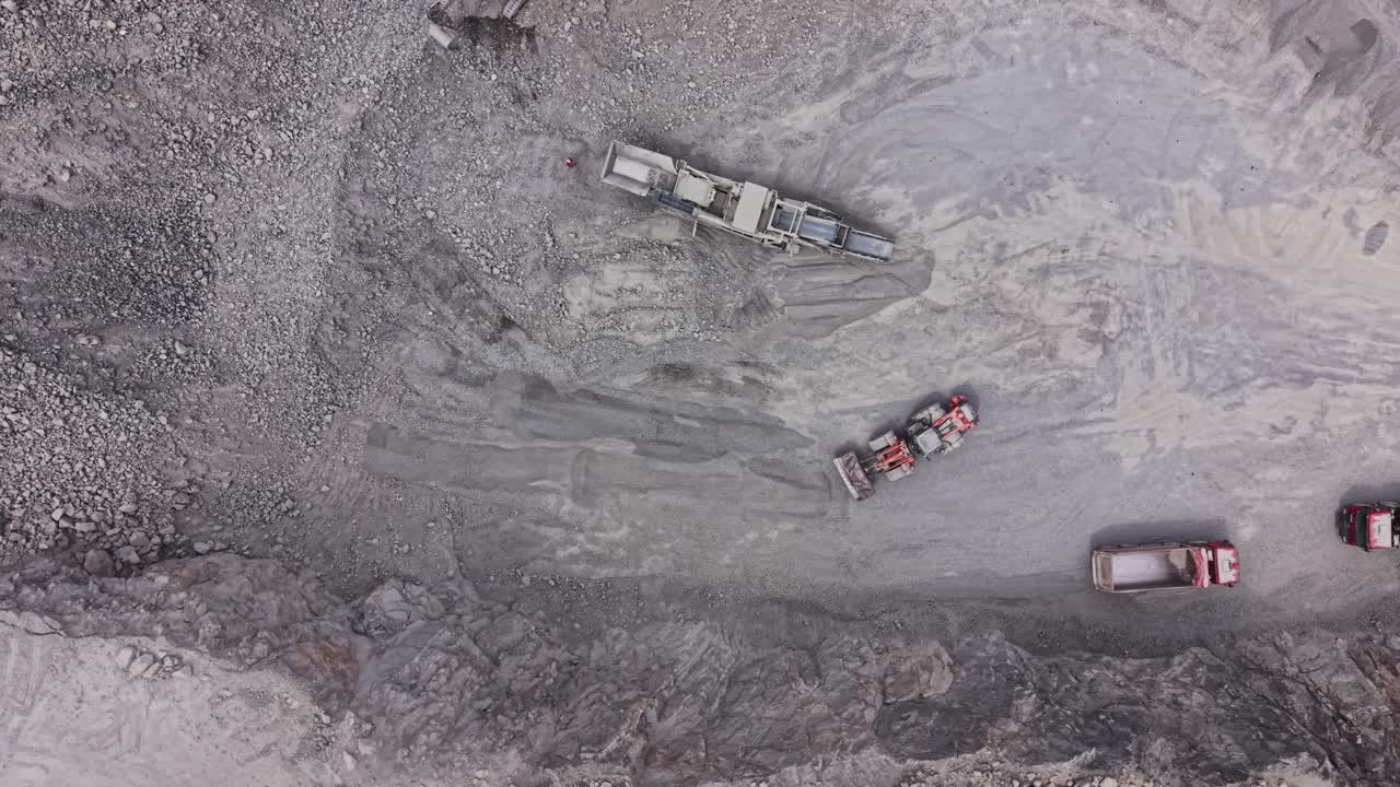 Trucks working on a construction site in a rocky area