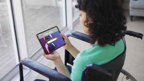 Biracial woman in wheelchair using tablet for online shopping, slow motion