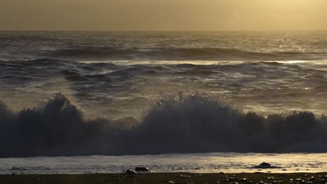 Ein-Raues-Wintermeer-Mit-Wellen,-Die-Auf-Einer-Schwarzen-Buche-In-Island-Krachen