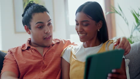 couple, tablet and talking on sofa in living room