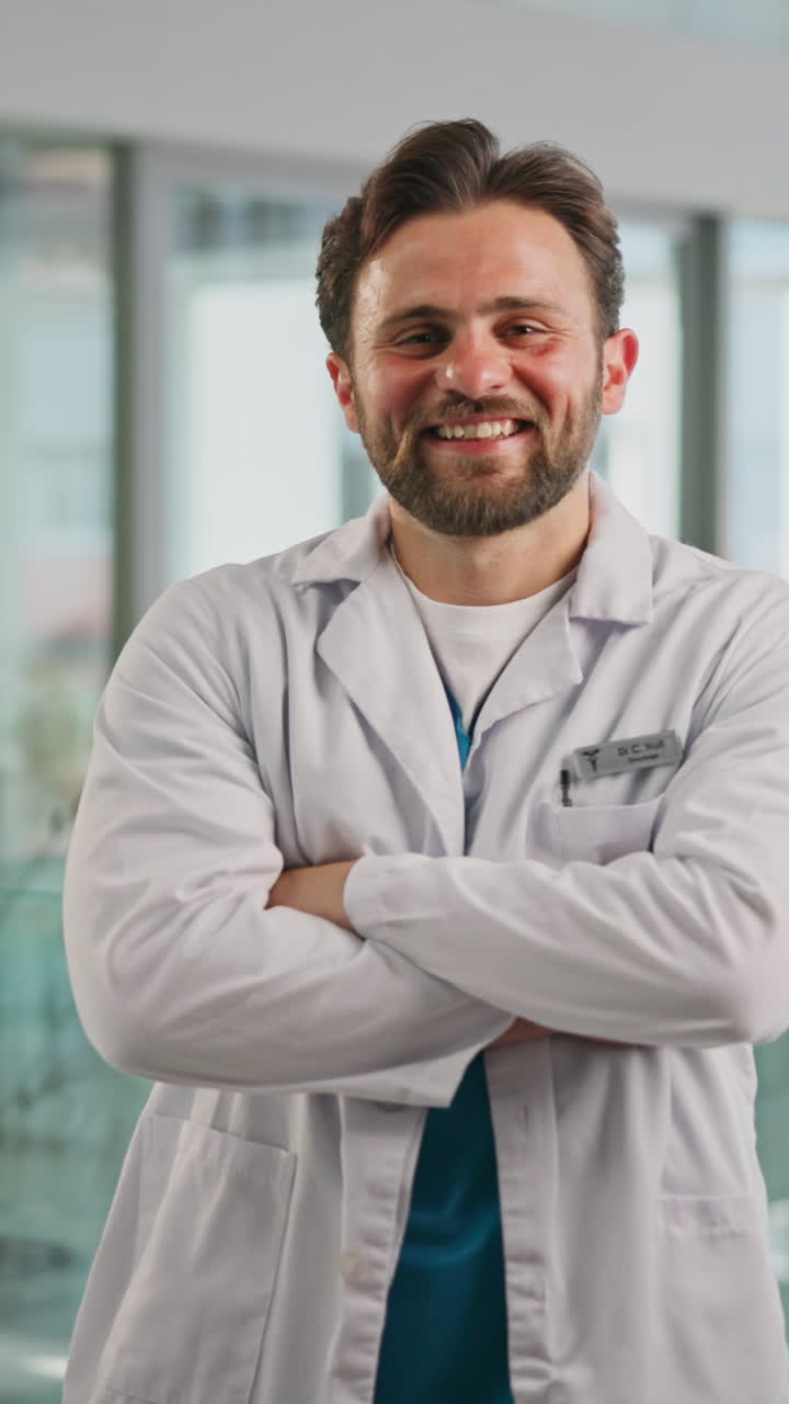 Médico seguro con bata de laboratorio sonriendo con los brazos cruzados