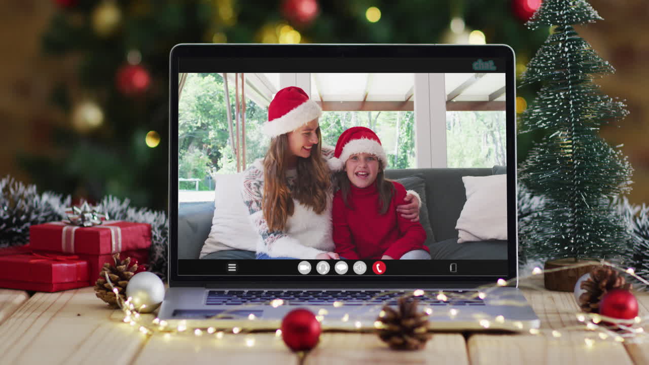 madre y hija felices en videollamada en computadora portátil, con decoraciones de navidad y árbol