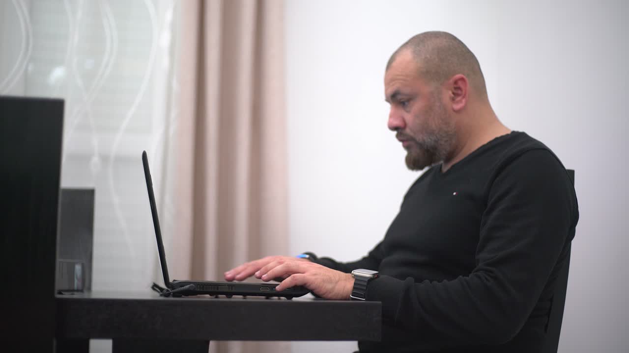 집 에서 컴퓨터 를 가지고 일 하고 시계 를 보는 사람