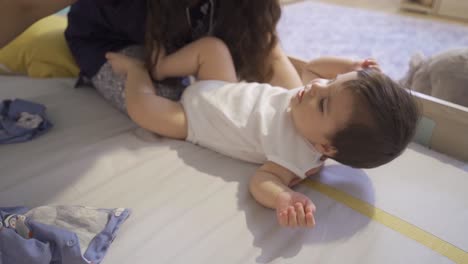 la madre quitándose el vestido de su bebé.