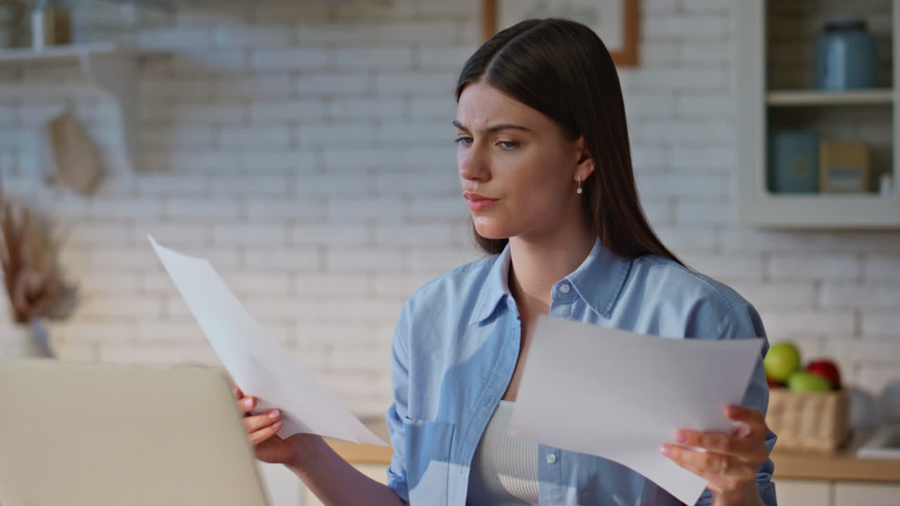 Videocalling girl examining documents talking at zoom meeting on laptop closeup