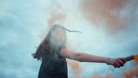 girl waving hand with smoke bomb on street. woman posing at camera