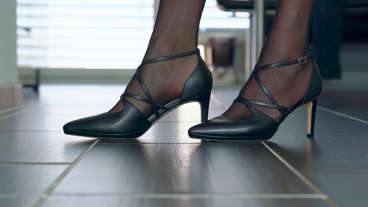 mostrando elegantes tacones de aguja frente a la cámara colocados en el suelo