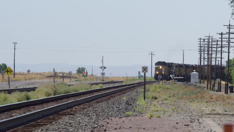un tren viaja a través del caluroso desierto de idaho en el verano entregando mercancías a lugares lejanos en 4k