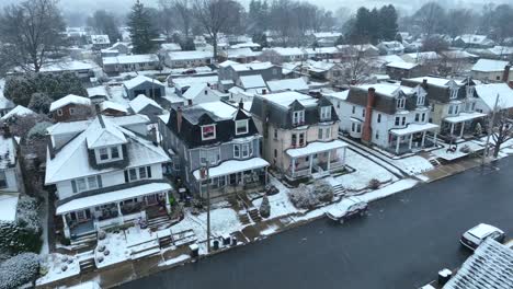 Copos-De-Nieve-Sobre-Una-Calle-Residencial-Con-Casas-En-Hilera,-árboles-Desnudos-Y-Autos-Estacionados