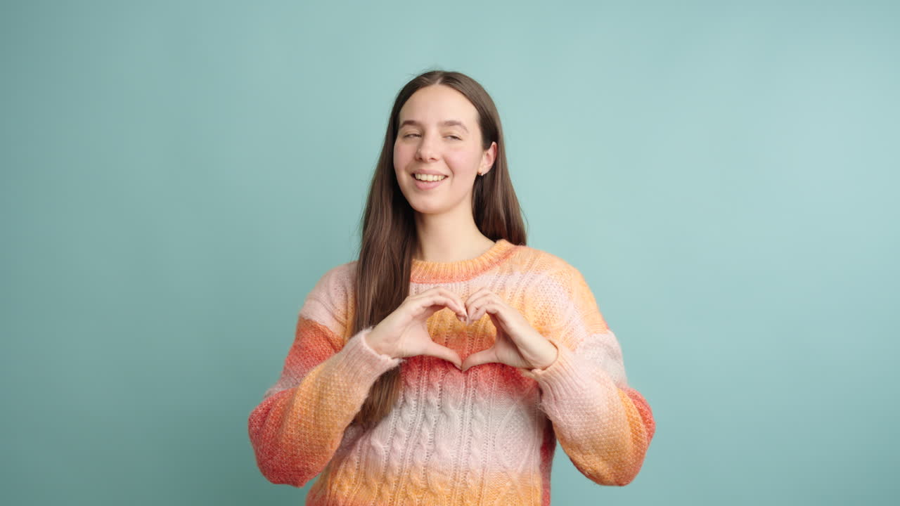Young woman expressing love and joy with hand gestures