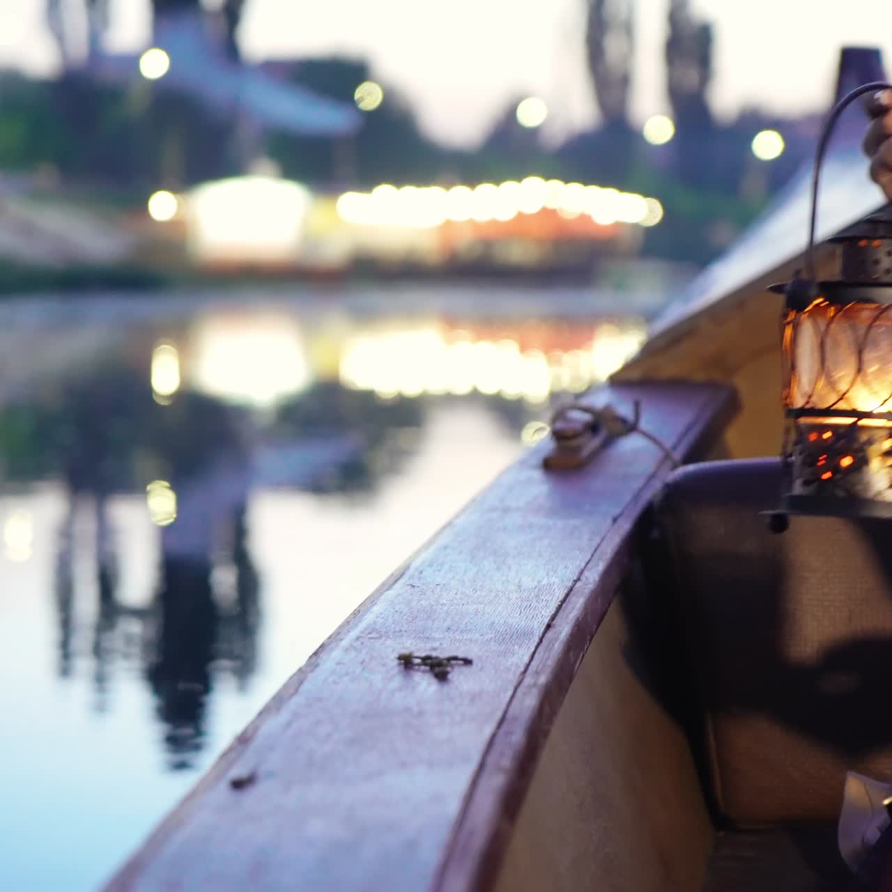 Close-up of a night lamp in female hands. Gondola floats along the river.