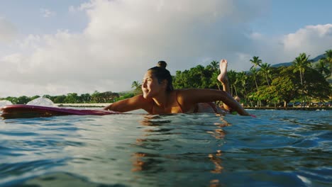 young woman surfing at sunset