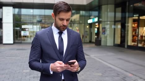 executive in suit using a cell phone while walking on the street.