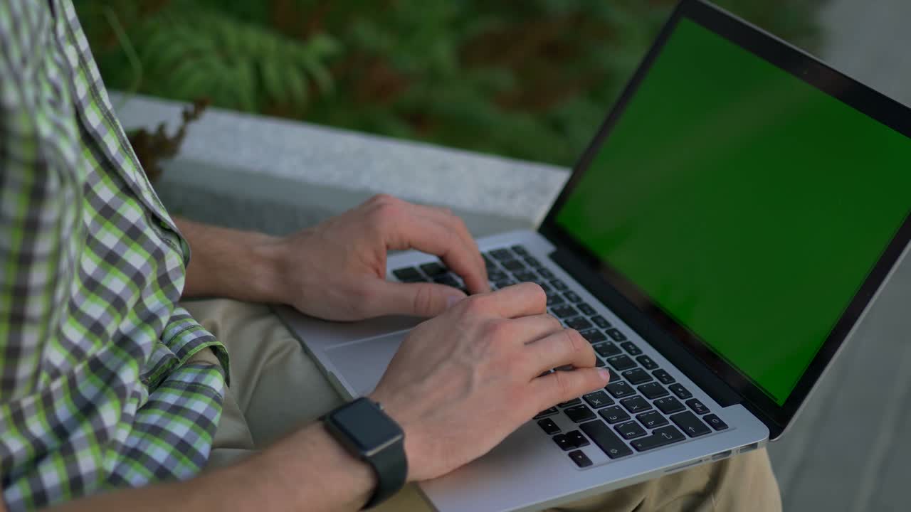 hombre trabajando en una computadora portátil al aire libre