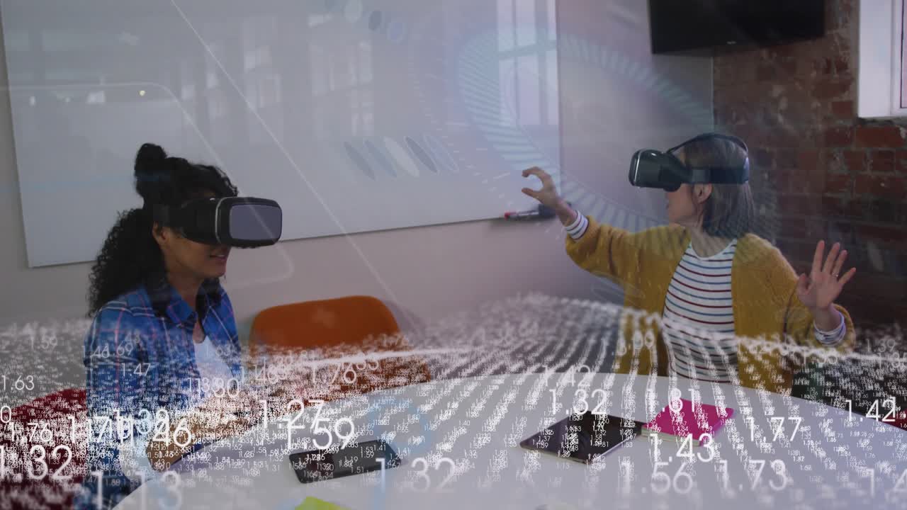 Two women in VR at table, data overlay appearing, one gesturing, other using pad, demoing tech
