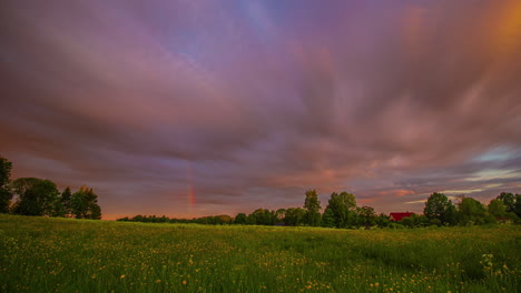 Zeitrafferaufnahme-Eines-Bunten-Regenbogens,-Der-An-Einem-Bewölkten-Tag-über-Grünen-Wiesen-Verblasst