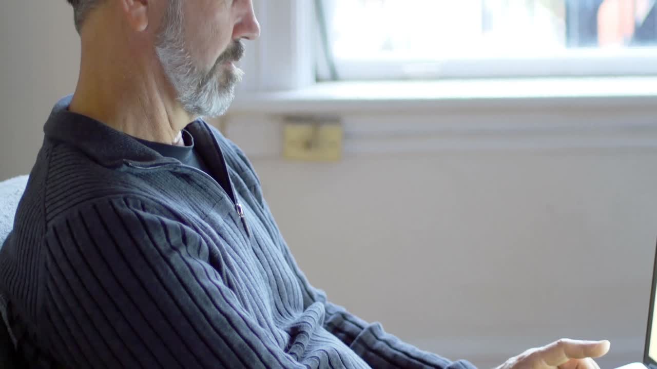 노트북을 사용하여 소파에서 휴식을 취하는 남자