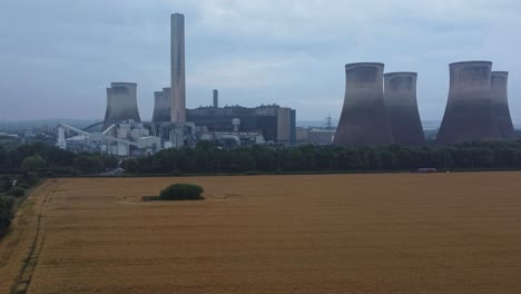 imponente torre de enfriamiento de hormigón estación de energía tierras de cultivo campo vista aérea izquierda tiro descendente