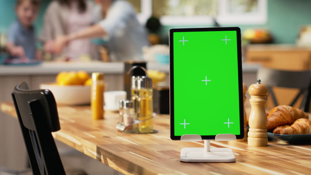 Vertical green screen on tablet near family smiling and preparing homemade pizza