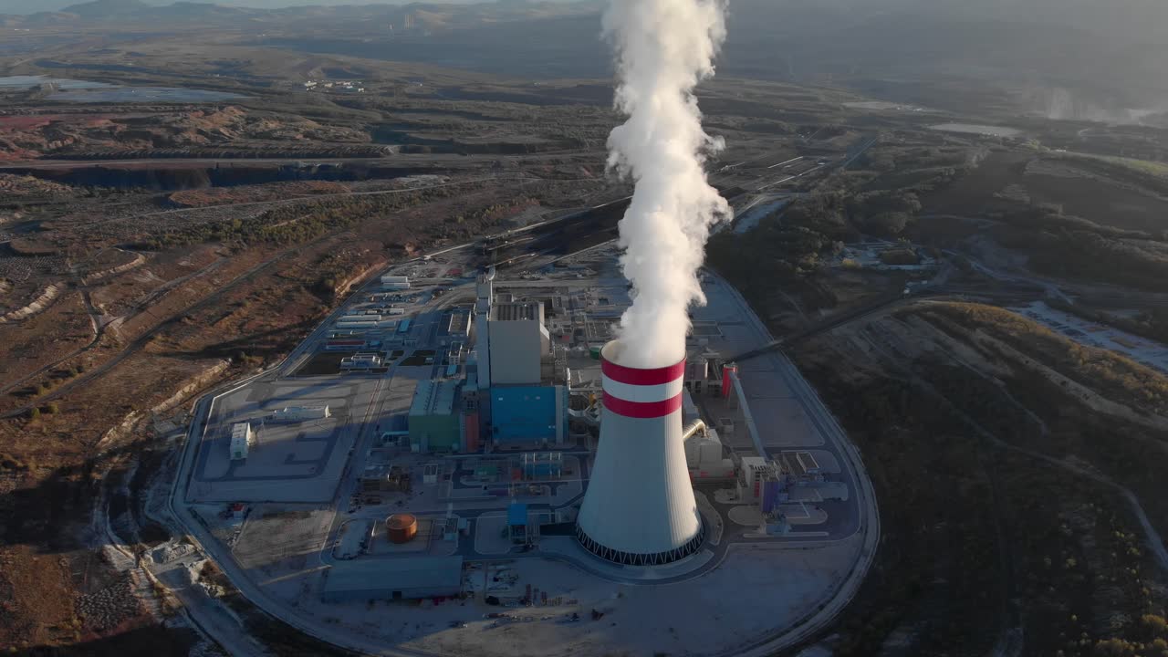Aerial view Smoke from a coal fired power plant chimney Tilt down Sunset