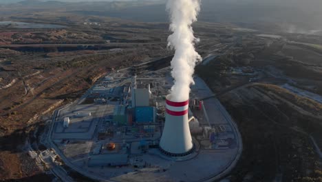 aerial view smoke from a coal fired power plant chimney tilt down sunset