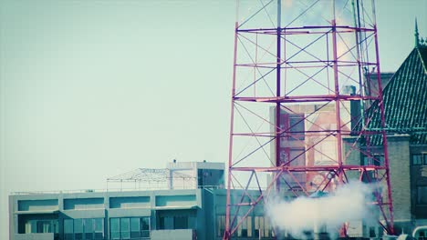 Smoke-billows-from-a-rooftop-with-a-radio-tower-on-it-in-downtown-Philadelphia,-PA