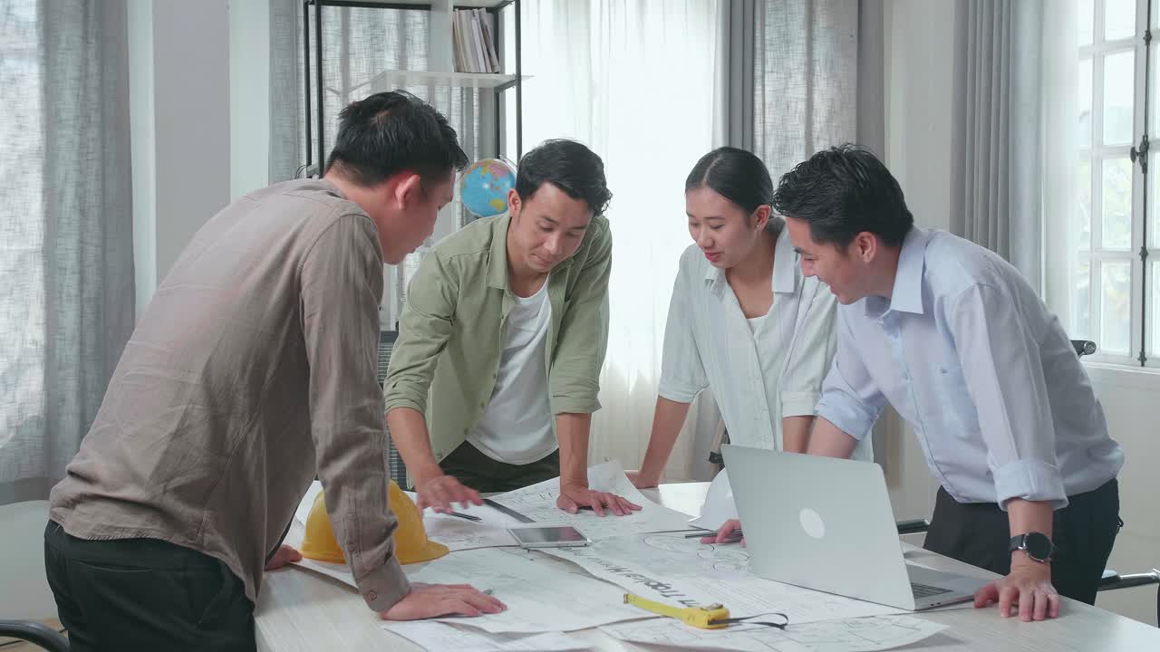Group Of Asian Engineers Discuss About Work On The Tablet At The Office