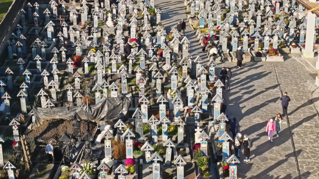Aerial drone view of The Merry Cemetery in Sapanta, Romania. Multiple tombstones and visitors