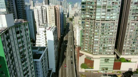toma aérea de mega rascacielos residenciales y tráfico en el centro de hong kong, en un hermoso día