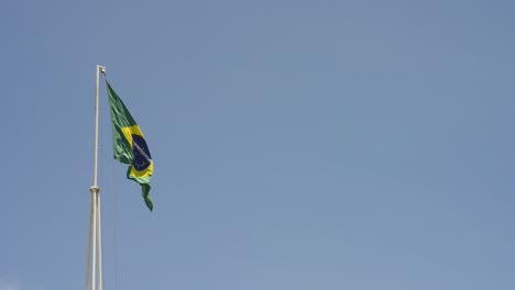 brazil national flag hoisted fluttering in blue sky day