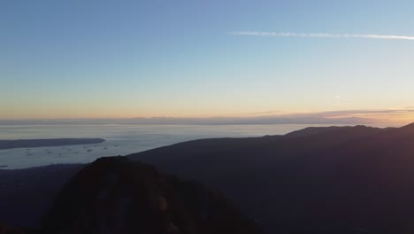 beautiful sunset over mountains with harbour bay with ships and city in distance