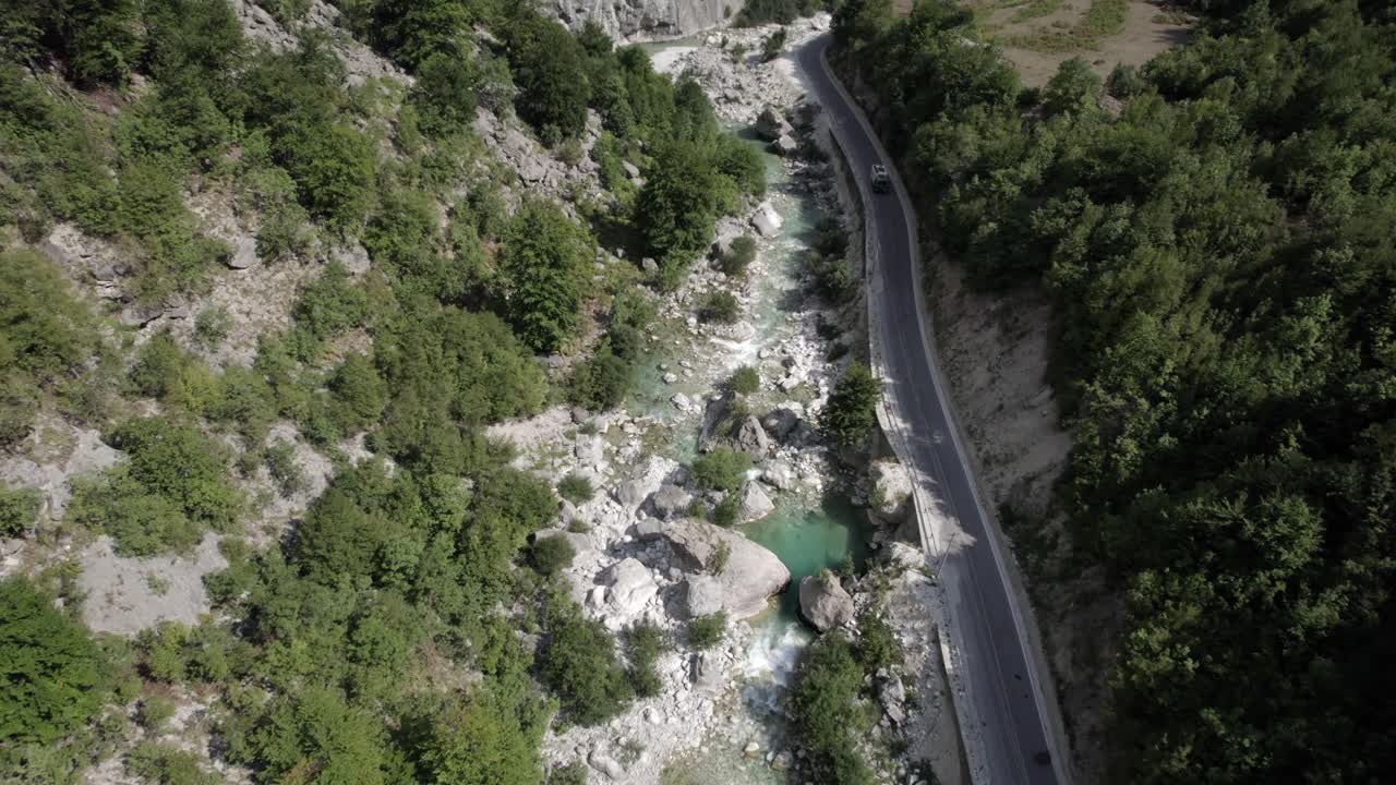 video con un dron del descubrimiento a vista de pájaro del plano frontal en el río valbone, albania, adjunto a la carretera