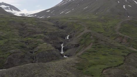 Luftaufnahme-Der-Atemberaubenden-Landschaft-In-Island,-Die-Auf-Einen-Abgelegenen-Wasserfall-Zufliegt