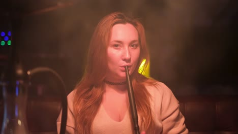 woman smoking hookah in night club