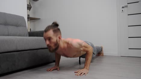 Athletic-Fit-Man-without-T-Shirt-Is-Doing-Push-Up-Exercises-at-home-in-his-living-room-with-minimalistic-interior