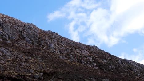 Nubes-Moviéndose-Contra-El-Cielo-Azul-Con-Terreno-Montañoso-Escarpado-De-Quinag-Sail-Gharbh-En-El-Distrito-De-Assynt,-Tierras-Altas-De-Escocia,-Reino-Unido