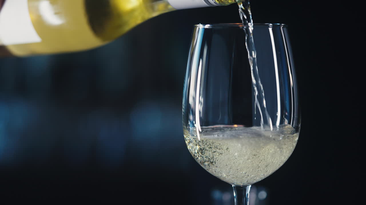 Versare il vino bianco in un bicchiere