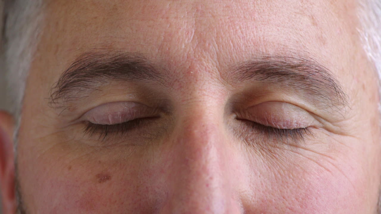 눈의 클로즈업과 눈을 쓰고 있는 성숙한 남자