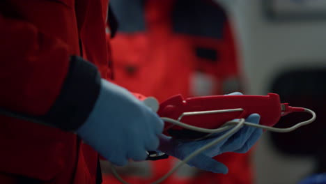 Unrecognizable-paramedic-holding-oximeter-device-in-hands