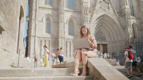 business woman sitting with laptop outdoor. girl getting message on computer