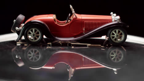 red vintage model car with reflection