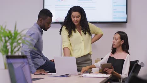 Happy-diverse-group-of-business-people-working-together,-using-laptop-in-modern-office