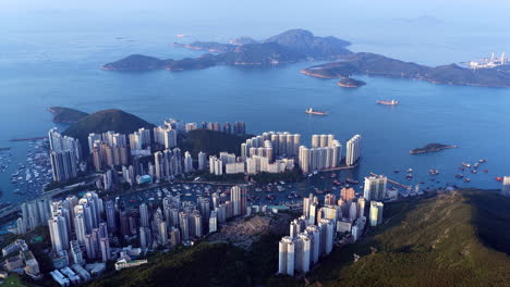 Cinematic aerial view of Hong Kong skyline shrouded in mist at blue hour, with glowing skyscrapers and Victoria Harbour fading into a moody, atmospheric twilight