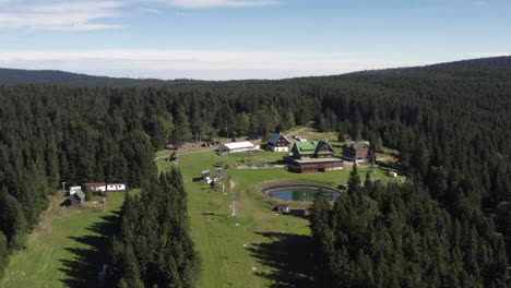 Pull-back-revealing-the-resort-chalets-at-Hotel-Paprsek-during-spring,-Czech-Republic,-aerial