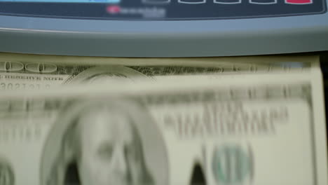 Counting-us-dollars-banknotes-on-currency-counter-machine.-Counting-paper-money