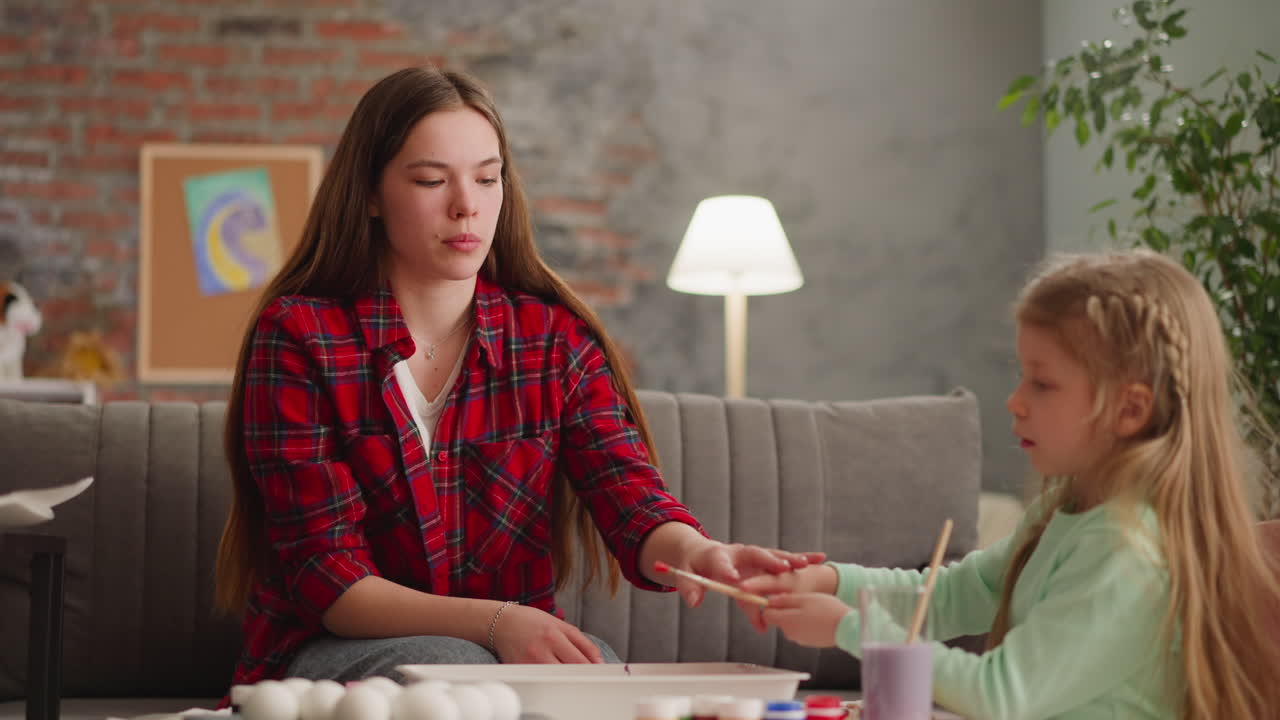 el joven maestro ayuda a la estudiante a gotear pintura para el arte ebru