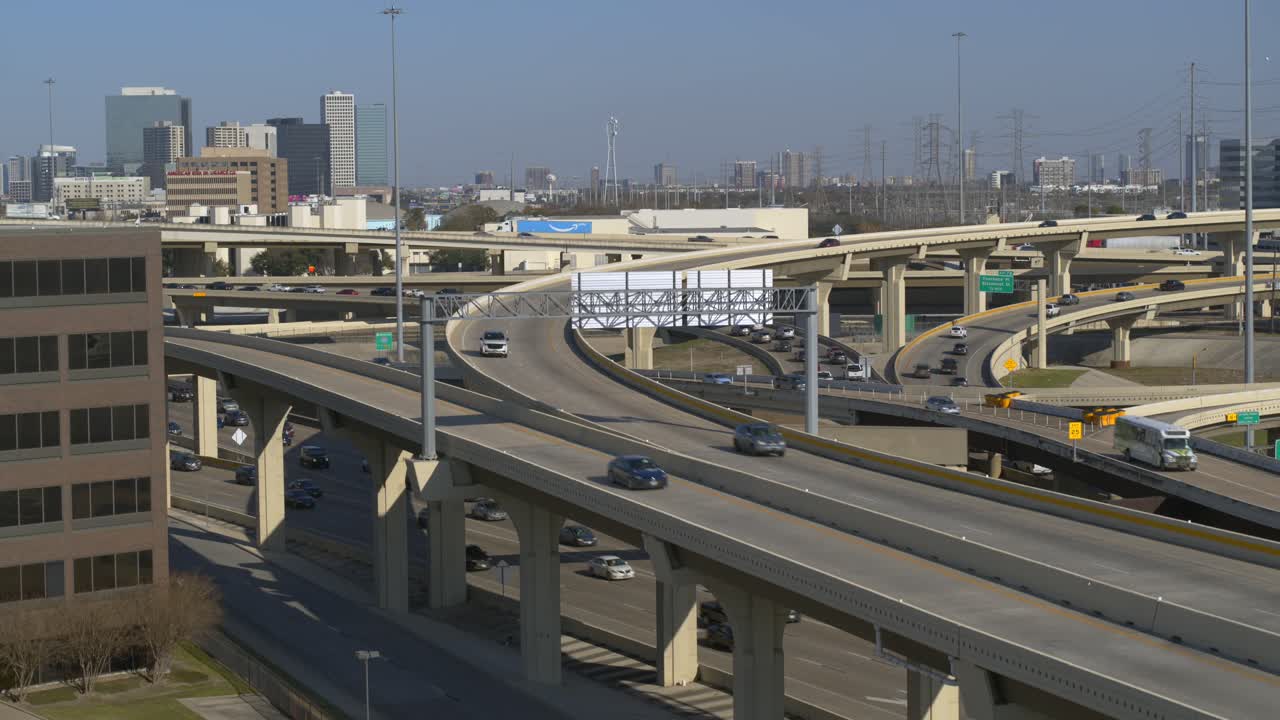 Dynamic aerial drone footage descending over a busy Houston freeway during rush hour, capturing heavy traffic flow and urban congestion. Ideal for news reports, transportation stories, documentaries,