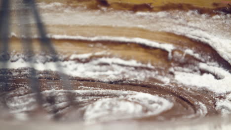 mixing of melted chocolate and flour with a whisk - closeup shot