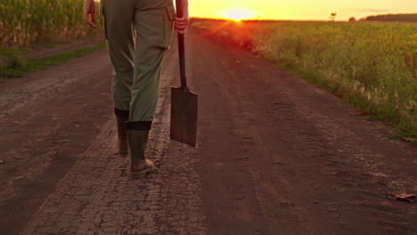 granjero caminando por un camino de tierra al atardecer